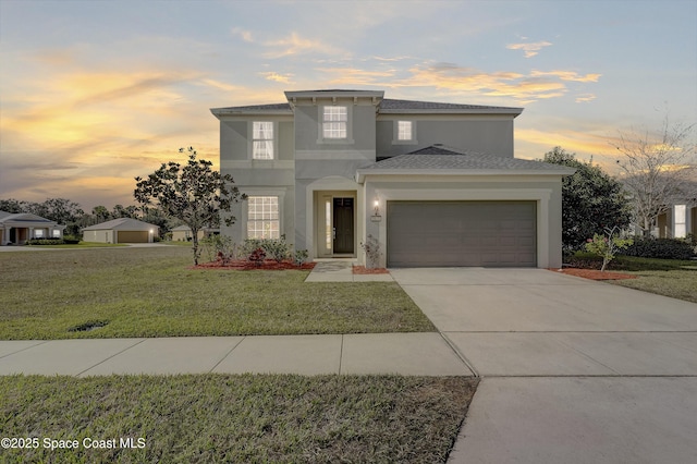 view of front of house featuring a garage and a lawn