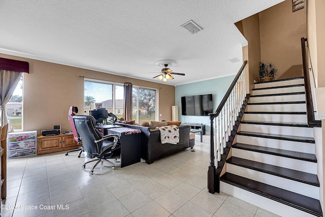 tiled living room with a textured ceiling and ceiling fan