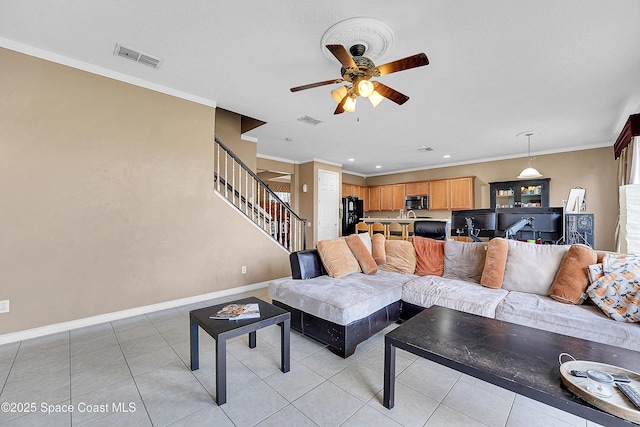 living room with light tile patterned floors, ornamental molding, and ceiling fan