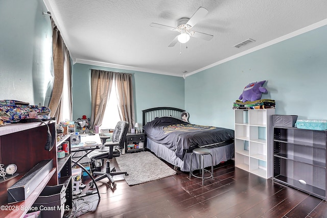 bedroom with dark hardwood / wood-style flooring, ceiling fan, ornamental molding, and a textured ceiling