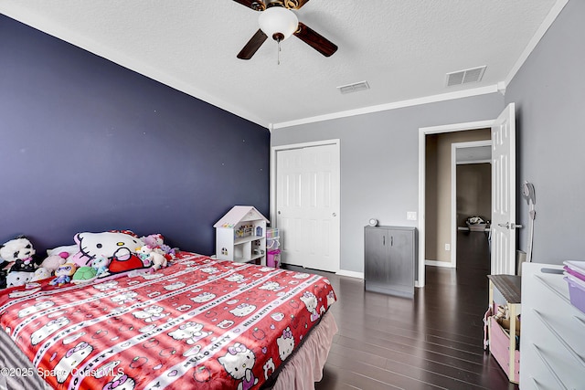 bedroom with dark wood-type flooring, crown molding, a textured ceiling, a closet, and ceiling fan