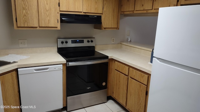 kitchen featuring light tile patterned floors and white appliances