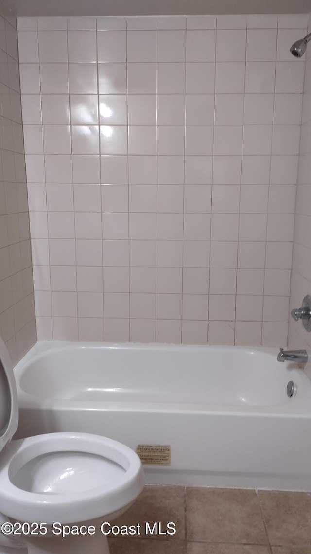 bathroom featuring tile patterned flooring, tiled shower / bath, and toilet