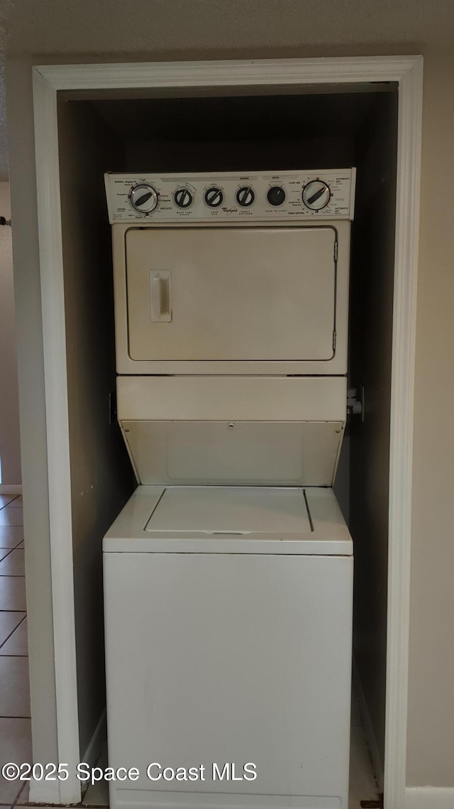 clothes washing area featuring stacked washer / drying machine