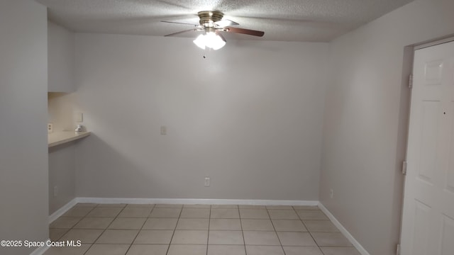 tiled empty room with a textured ceiling and ceiling fan