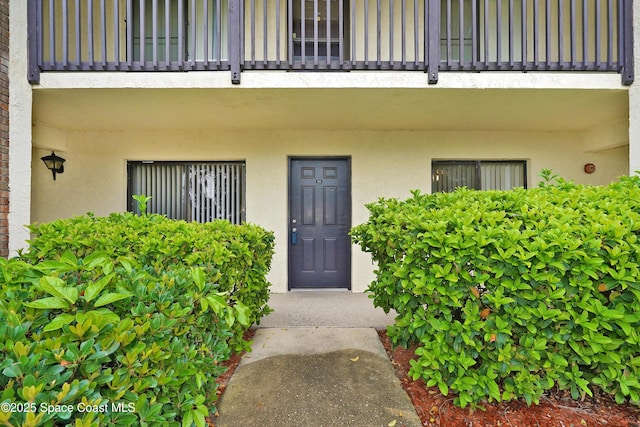 doorway to property featuring a balcony and stucco siding