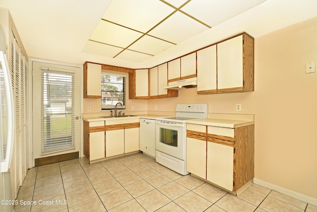 kitchen with white appliances, light countertops, under cabinet range hood, a sink, and light tile patterned flooring