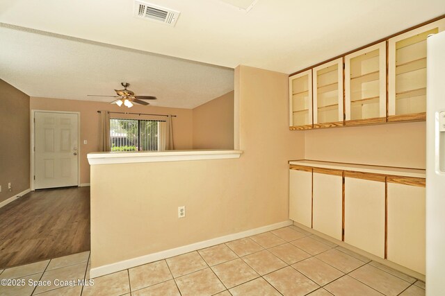 empty room with visible vents, ceiling fan, baseboards, and light tile patterned floors