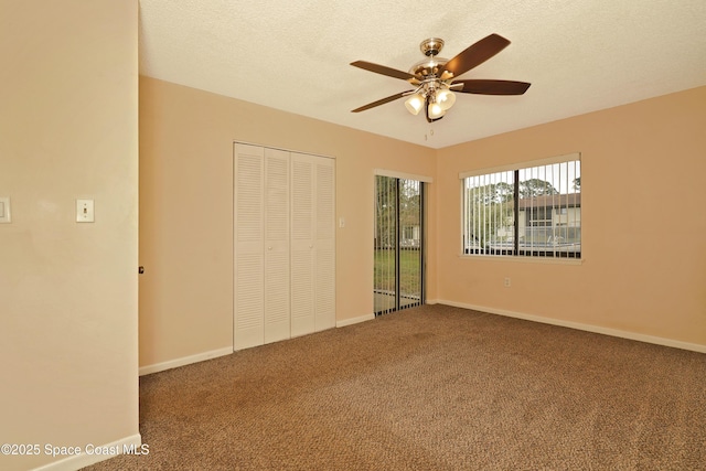 unfurnished bedroom featuring carpet, baseboards, and a textured ceiling