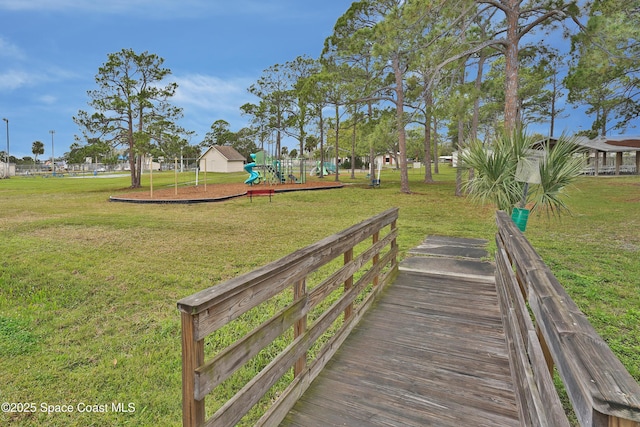 view of property's community featuring playground community and a lawn