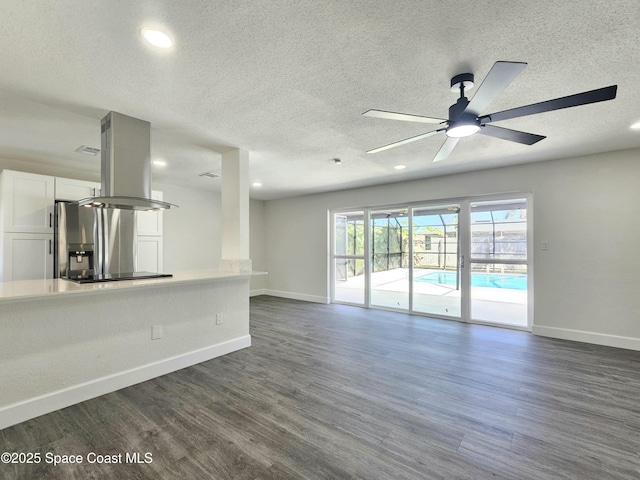 unfurnished living room with dark wood-type flooring, ceiling fan, and a textured ceiling