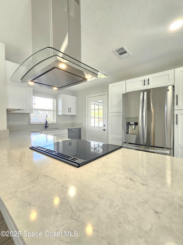 kitchen featuring white cabinetry, stainless steel appliances, light stone counters, and a wealth of natural light