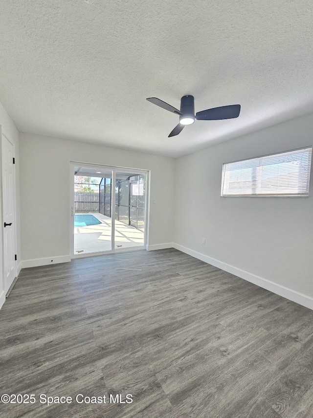 empty room with ceiling fan, a textured ceiling, and dark hardwood / wood-style flooring