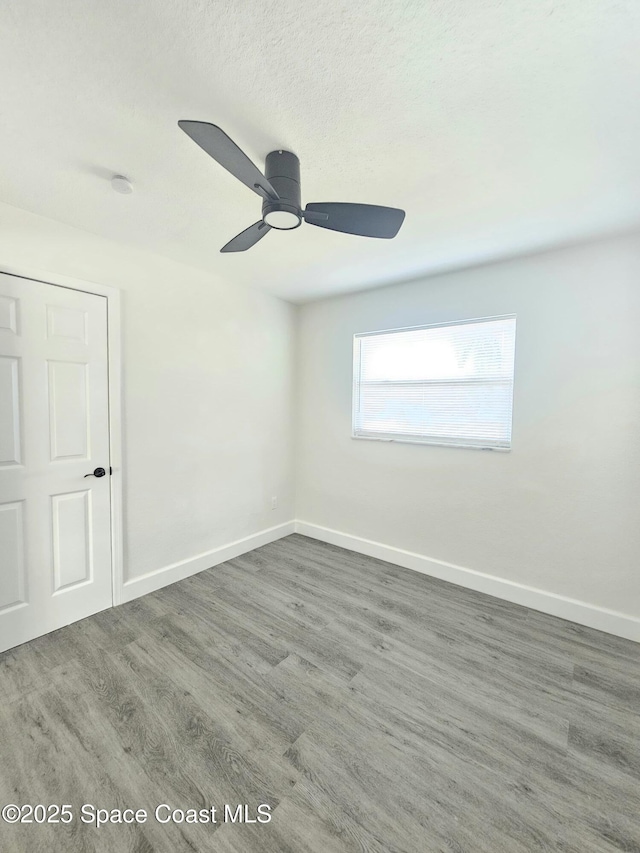 unfurnished room featuring dark wood-type flooring, a textured ceiling, and ceiling fan