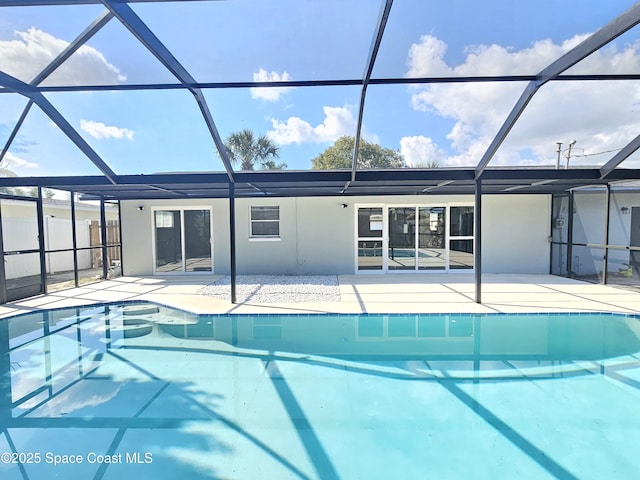 back of property with a patio and glass enclosure