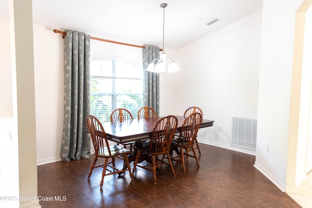 dining area featuring dark hardwood / wood-style floors and an inviting chandelier