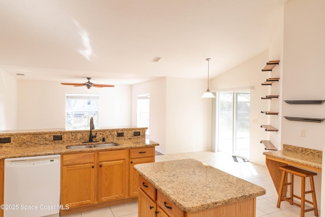 kitchen with an island with sink, sink, hanging light fixtures, light tile patterned floors, and white dishwasher