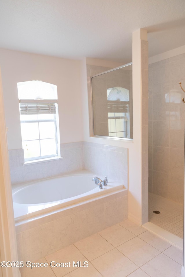 bathroom with independent shower and bath and tile patterned flooring