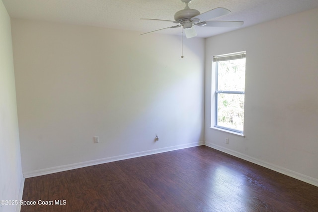 empty room with ceiling fan and dark hardwood / wood-style flooring