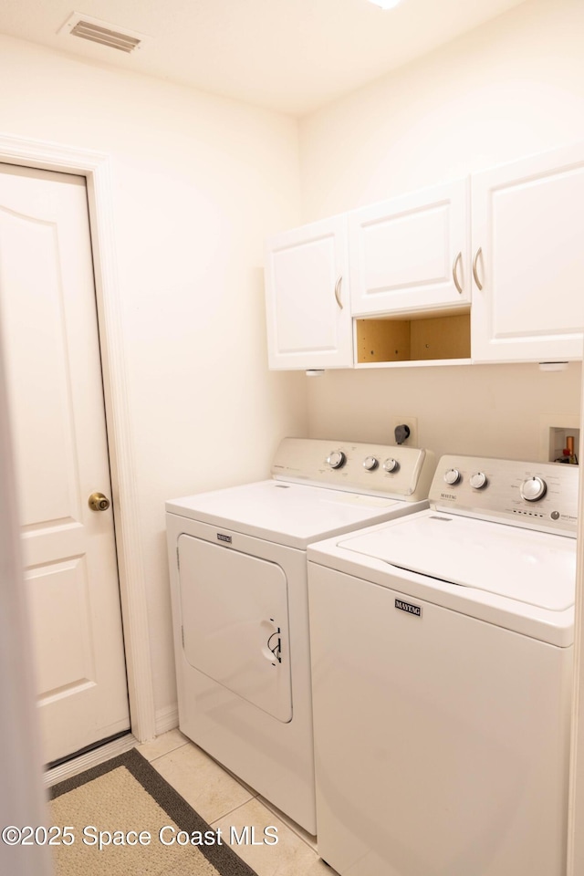 laundry area with independent washer and dryer and cabinets