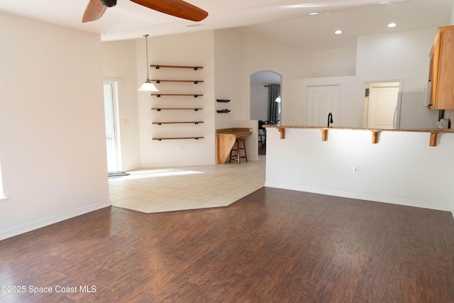 empty room featuring high vaulted ceiling, ceiling fan, and light hardwood / wood-style flooring