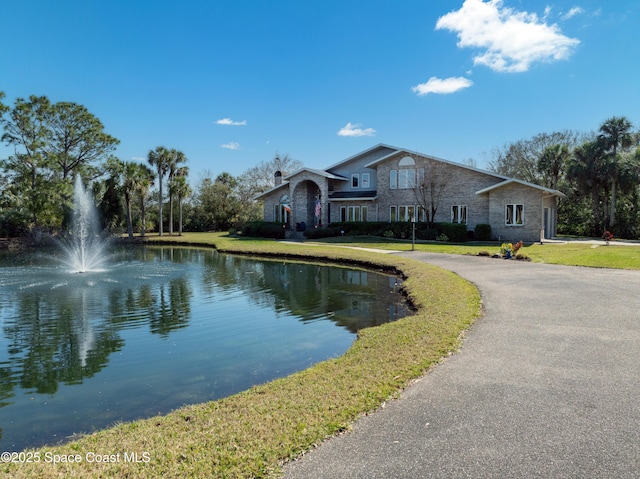 exterior space featuring a water view and a front lawn