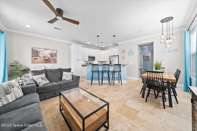 living room with ceiling fan with notable chandelier and ornamental molding