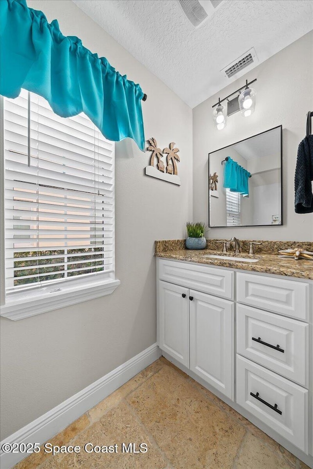 bathroom with vanity and a textured ceiling