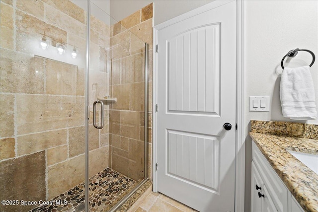 bathroom featuring a shower with door and vanity