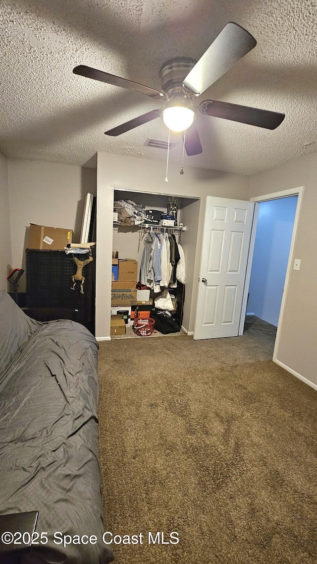 bedroom featuring ceiling fan, carpet flooring, a textured ceiling, and a closet