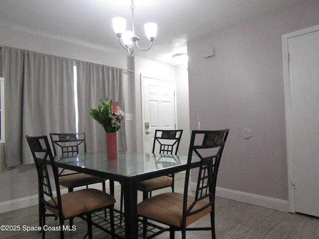 dining space with hardwood / wood-style floors and a chandelier