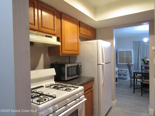 kitchen with white range with gas stovetop and light hardwood / wood-style flooring