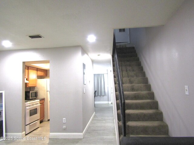 stairs with hardwood / wood-style flooring