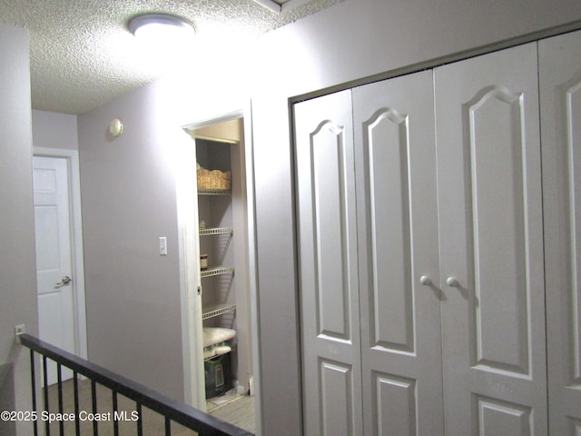 hall featuring a textured ceiling