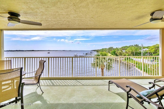 balcony with a water view and ceiling fan