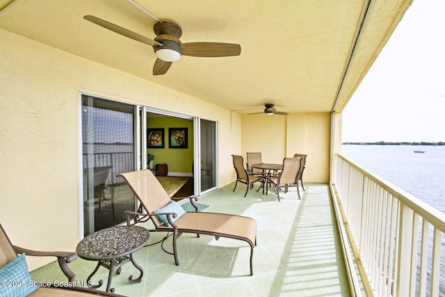 balcony with ceiling fan and a water view