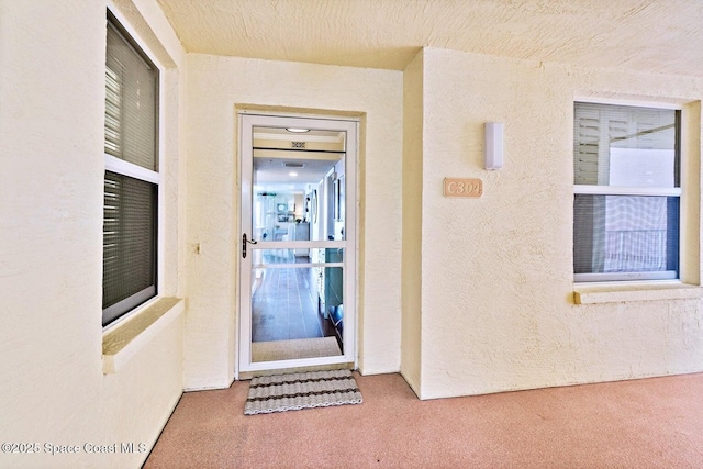 doorway to property featuring stucco siding