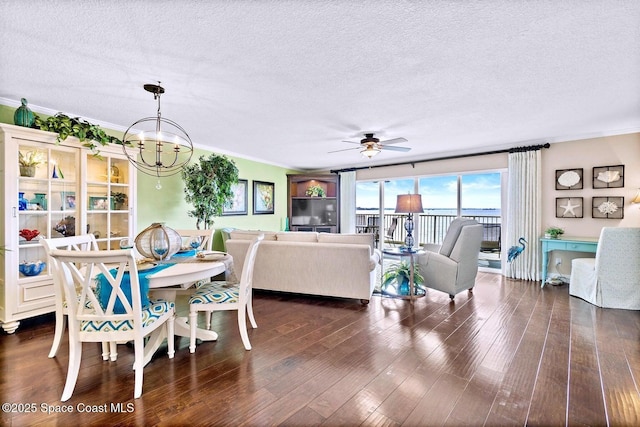 dining room with crown molding, a textured ceiling, dark wood-type flooring, and ceiling fan with notable chandelier