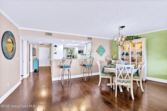 dining area with dark wood finished floors and crown molding