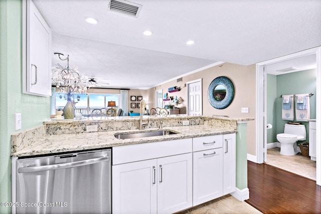 kitchen with visible vents, white cabinets, dishwasher, light stone counters, and a sink