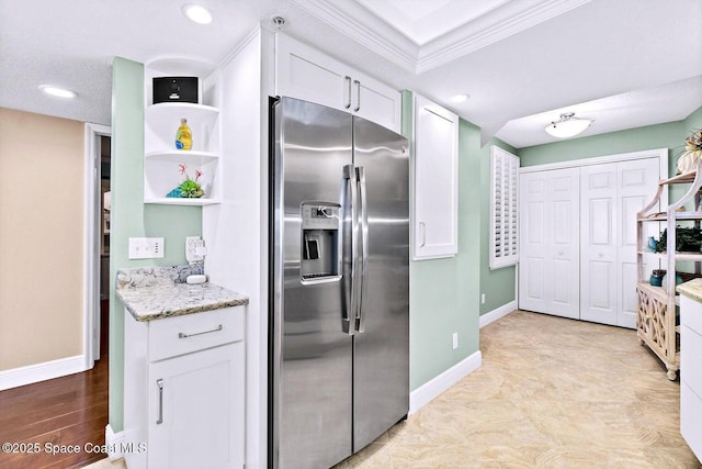 kitchen with baseboards, white cabinetry, stainless steel refrigerator with ice dispenser, and light stone counters