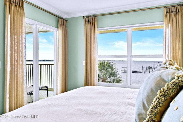 bedroom with a water view, ornamental molding, and access to exterior