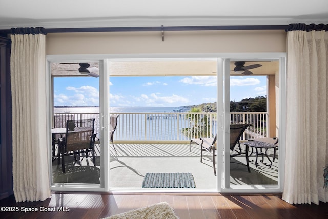 doorway to outside with a ceiling fan, a water view, and wood finished floors