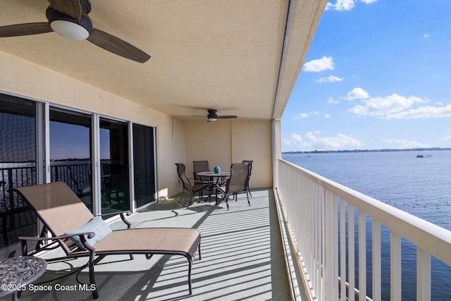 balcony featuring ceiling fan and a water view