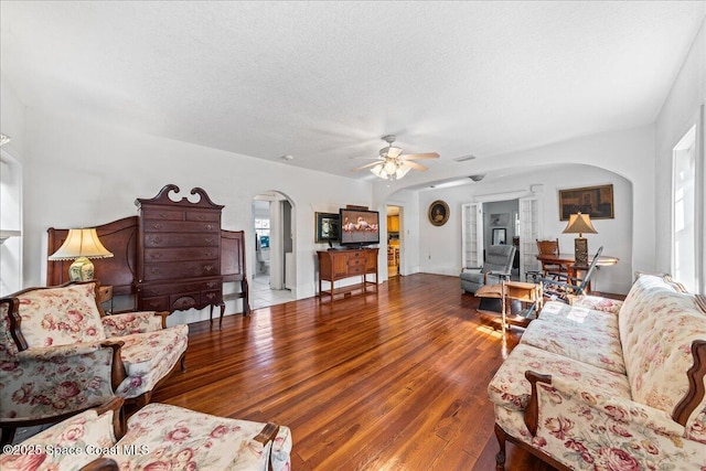 living room with ceiling fan, hardwood / wood-style floors, and a textured ceiling