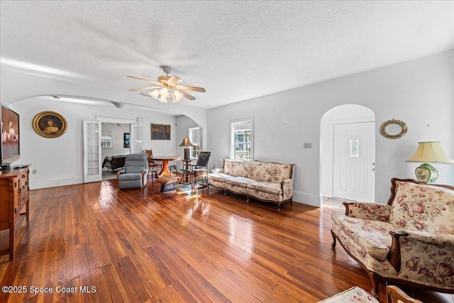 living room featuring hardwood / wood-style floors, a textured ceiling, and ceiling fan