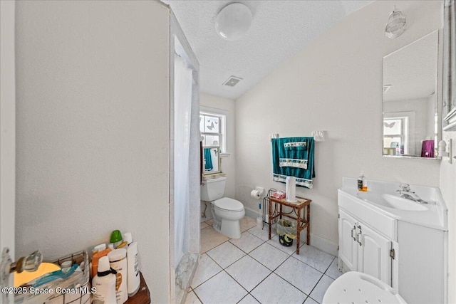 bathroom with tile patterned floors, toilet, a textured ceiling, and vanity