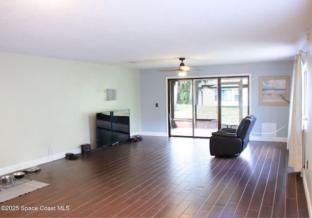 living area with ceiling fan and dark hardwood / wood-style flooring