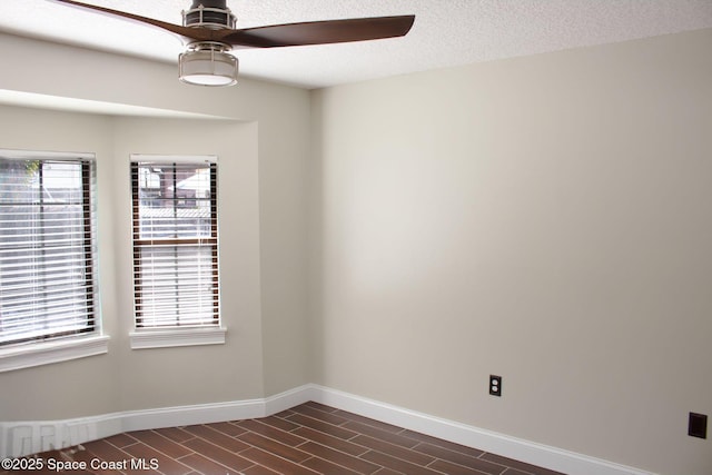 unfurnished room with ceiling fan and a textured ceiling