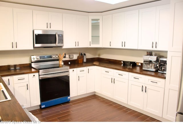 kitchen featuring white cabinetry, appliances with stainless steel finishes, and butcher block countertops